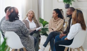  A group of people sitting in a circle having a discussion about the benefits of an HOA, with one person holding a notepad.